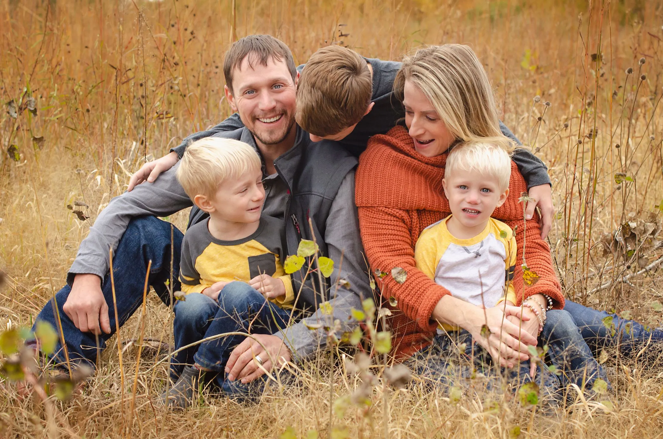 A family of five enjoying an autumn field together